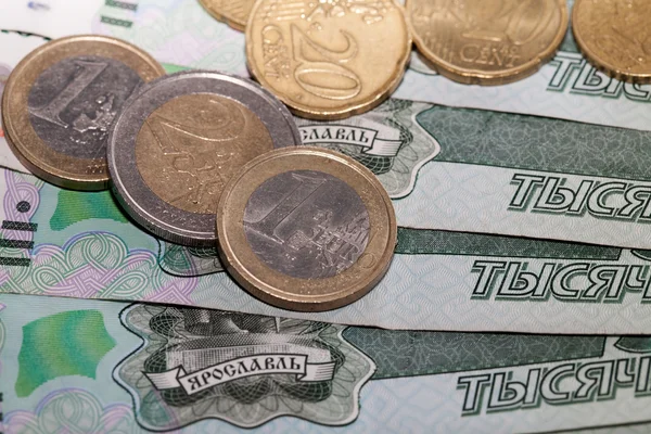 Euromynt på en bakgrund av tusen rubel sedlar — Stockfoto