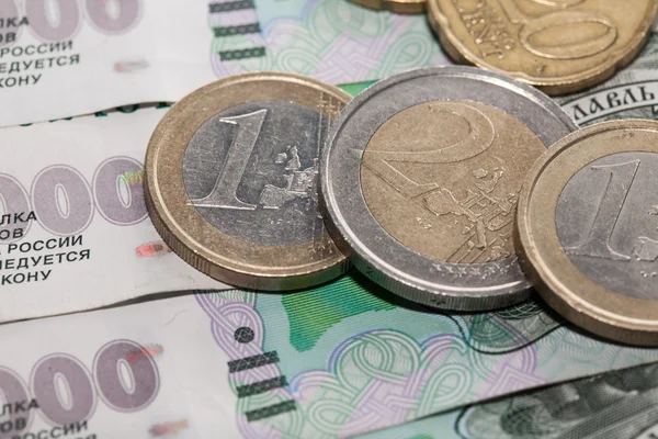 Euro-Münzen auf einem Hintergrund von Tausend-Rubel-Banknoten — Stockfoto