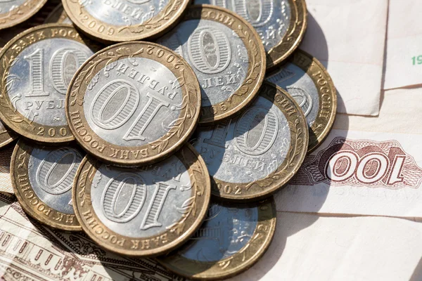 Moneda diez rublos en un papel de fondo notas por valor de cien rublos — Foto de Stock