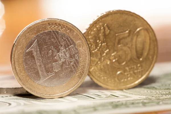 欧元硬币美元的背景上 — 图库照片