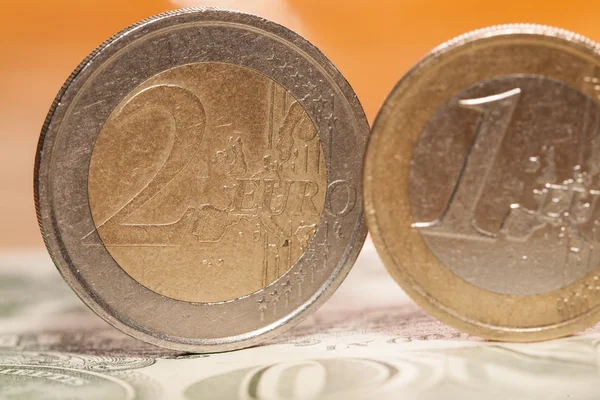 Монеты евро на фоне долларов — стоковое фото