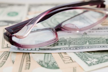 Bize dolar banknotların arka planda gözlük