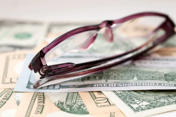 Brille auf dem Hintergrund von uns Dollarnoten — Stockfoto