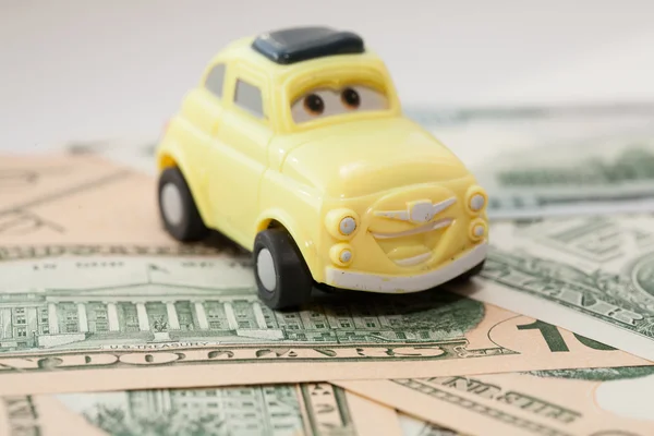 Toy car on a background of US dollars banknotes — Stock Photo, Image