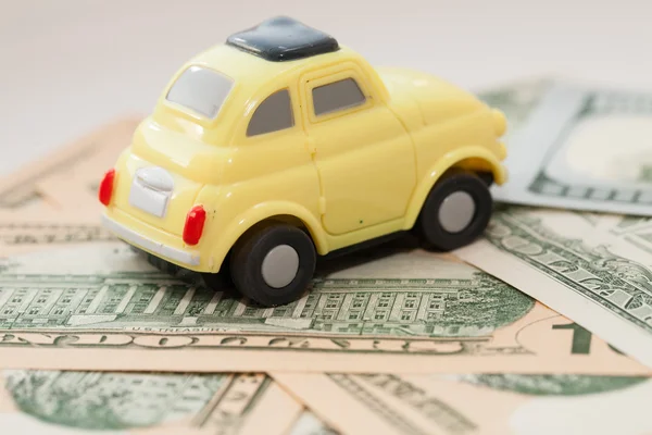 Toy car on a background of US dollars banknotes — Stock Photo, Image