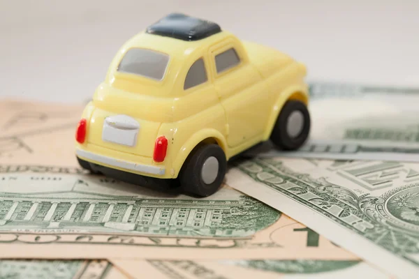Toy car on a background of US dollars banknotes — Stock Photo, Image