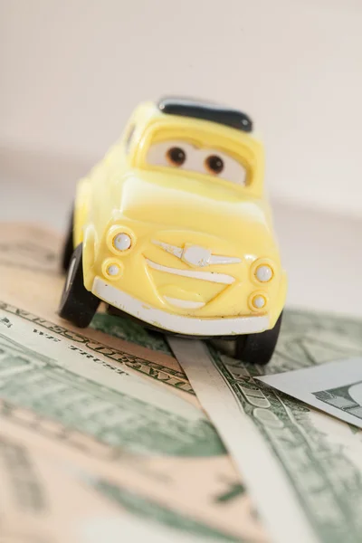 Toy car on a background of US dollars banknotes — Stock Photo, Image