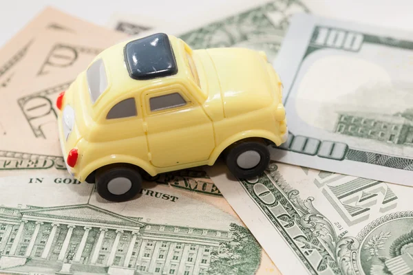 Toy car on a background of US dollars banknotes — Stock Photo, Image