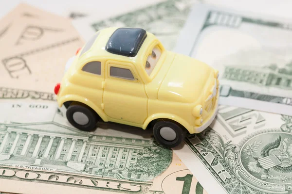 Toy car on a background of US dollars banknotes — Stock Photo, Image