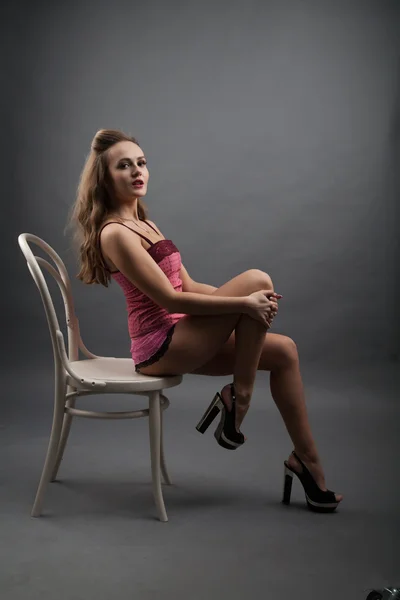 Girl in pink lingerie sitting on a chair — Stock Photo, Image