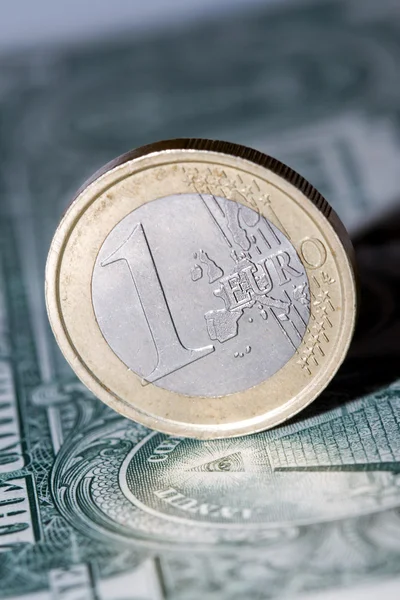 One euro coin on a dollar bill — Stock Photo, Image