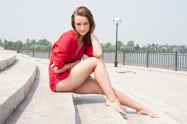 Κορίτσι με ένα κόκκινο πουκάμισο στα πέτρινα σκαλοπάτια — Φωτογραφία Αρχείου