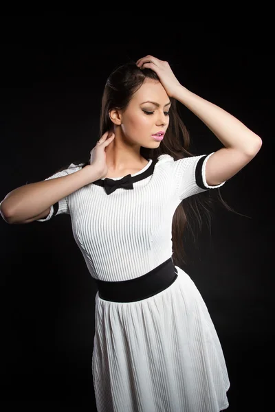 Young girl in a white dress on a black background — Stock Photo, Image