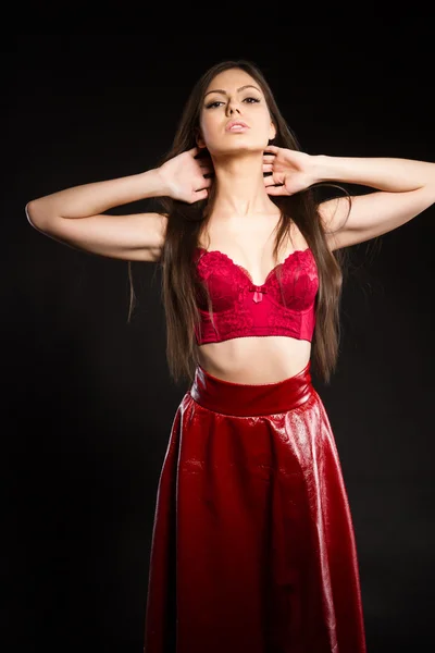 Flicka i röd lång kjol och behå. studiofotografering — Stockfoto