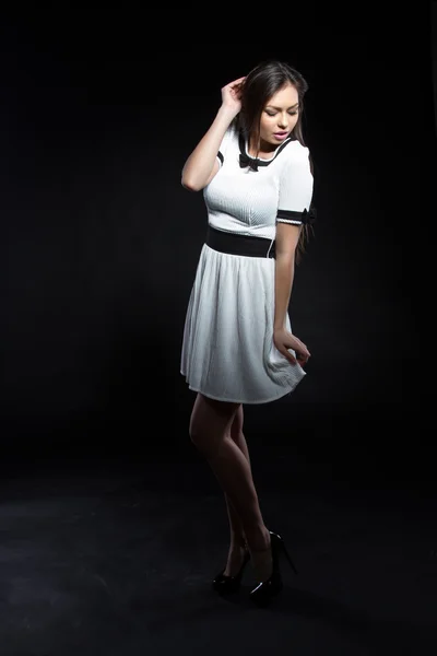 Menina em vestido branco em um fundo preto — Fotografia de Stock