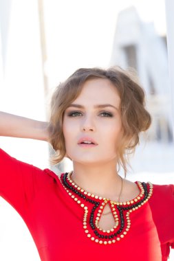 Duvara karşı duran Kırmızı elbiseli kız