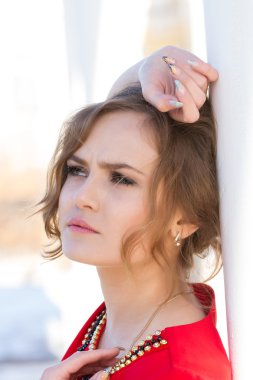 Duvara karşı duran Kırmızı elbiseli kız