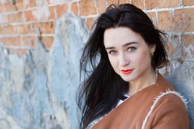 Bir tuğla duvar arka planda bir kağıt bardak kızla