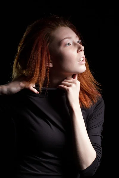 Girl with red hair on a black background — Stock Photo, Image