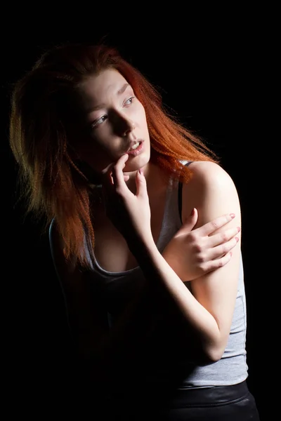 The girl with red hair on a black background. Studio portrait — Stock Photo, Image