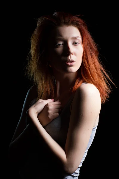 The girl with red hair on a black background. Studio portrait — Stock Photo, Image