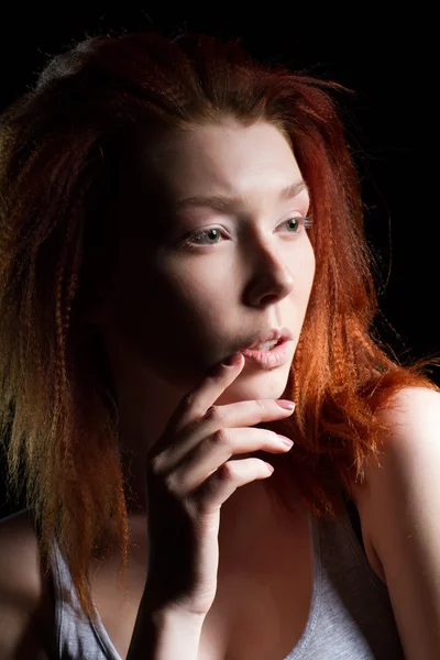 A menina com cabelo vermelho em um fundo preto. Retrato de estúdio — Fotografia de Stock