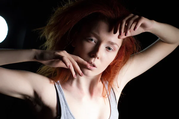 The girl with red hair on a black background. Studio portrait — Stock Photo, Image