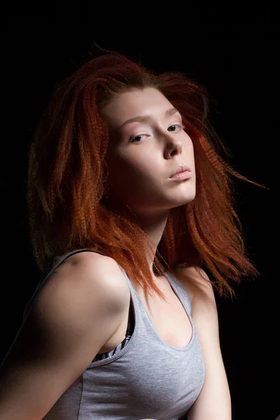 The girl with red hair on a black background. Studio portrait — Stock Photo, Image