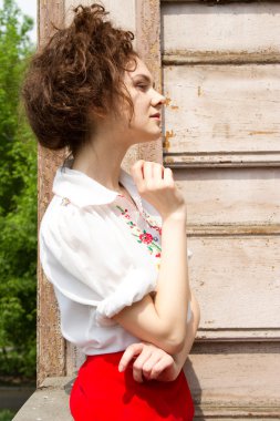 Beyaz işlemeli gömlek daimi bir ahşap evin verandada genç kız