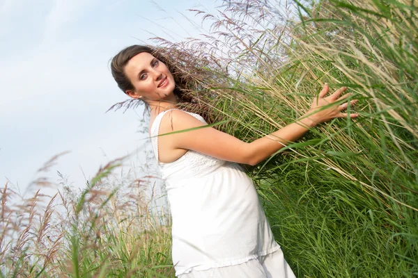 Pregnant woman among the tall grass — Stock Photo, Image
