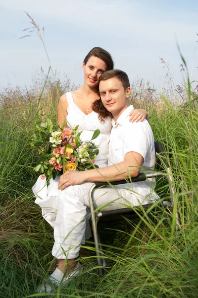 Gelukkig jonge man en zijn zwangere vrouw ontspannen over aard — Stockfoto