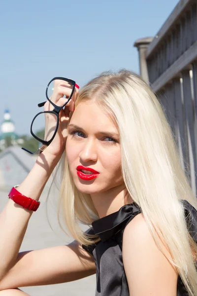 Portret van de blonde met felle lippenstift tegen de hemel — Stockfoto