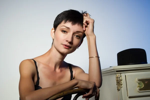 Girl in lingerie sitting on a chair. Studio portrait — Stock Photo, Image