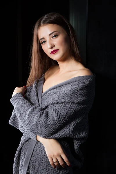 Girl standing at the window in a dark room — Stock Photo, Image