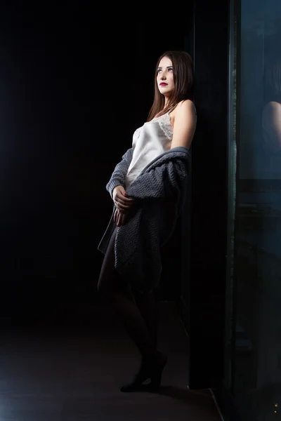 Lány állt az ablaknál egy sötét szobában — Stock Fotó