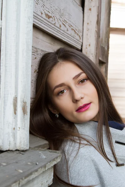 Chica joven con el pelo largo sobre un fondo de la vieja casa — Foto de Stock