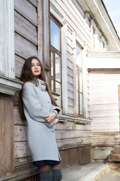 Young girl with long hair on a background of the old house — Stock Photo, Image