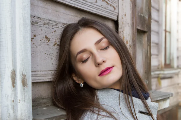 Young girl with long hair on a background of the old house — Stock Photo, Image