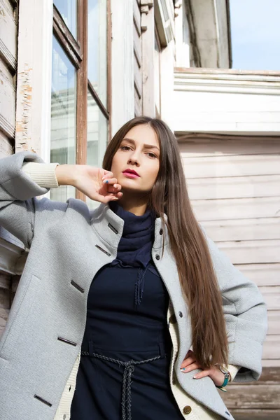 Jong meisje op een achtergrond van een oud houten huis — Stockfoto