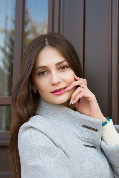 Young girl on the background of the door of the office building — Stock Photo, Image