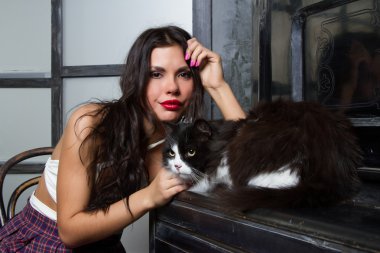 Piyanonun oturan bir kedi kız