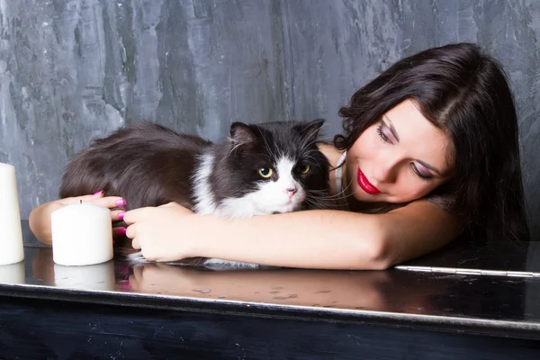 Girl with a cat at the piano — Stock Photo, Image