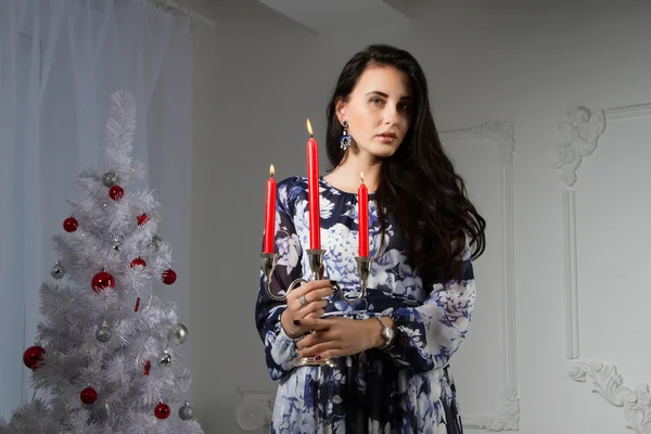 Jong meisje met kaarsen op de kerstboom — Stockfoto