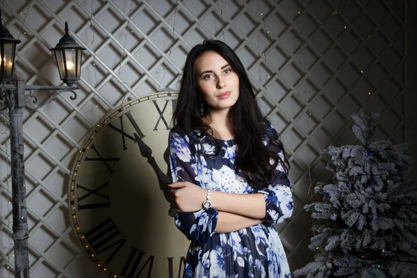 Girl at the Christmas tree in the background of a large dial — Stock Photo, Image