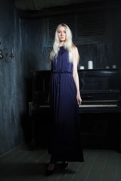 Κορίτσι σε νυχτερινό φόρεμα σε ένα φόντο του πιάνου — Φωτογραφία Αρχείου