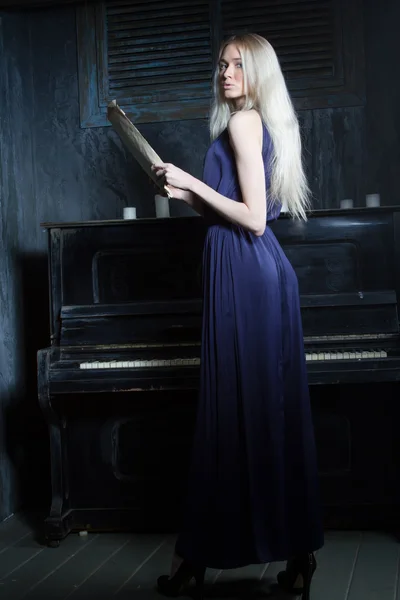 Chica en un vestido de noche en un fondo de piano —  Fotos de Stock