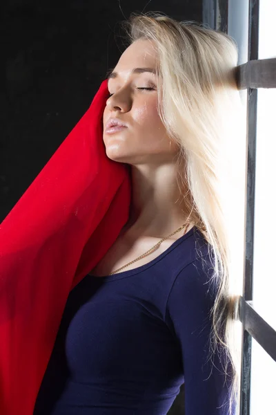 Young blonde with a red scarf in the window — Stock Photo, Image