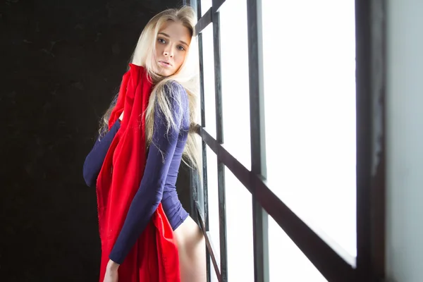 Young blonde with a red scarf in the window — Stock Photo, Image