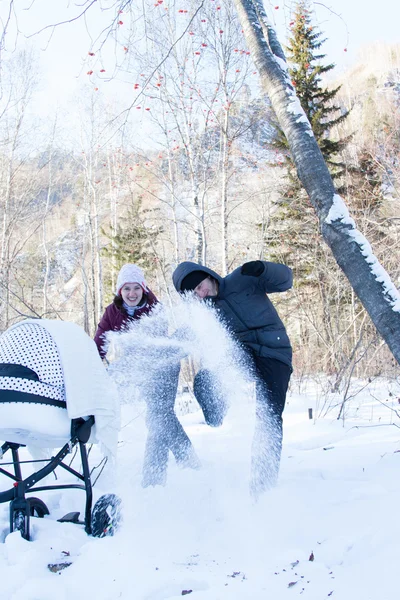 Man and woman make their way through the drifts with pram — Stock Photo, Image