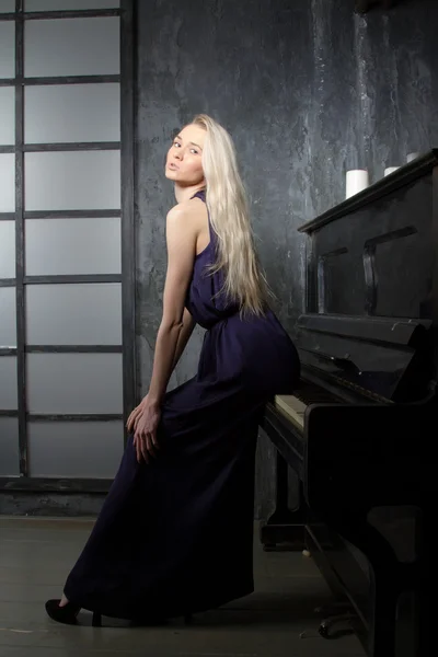 Blonde girl in evening dress at the piano — Stock Photo, Image